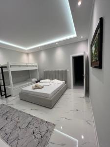 ein weißes Schlafzimmer mit einem Bett und einem Gemälde an der Wand in der Unterkunft Guesthouse BellaVista in Berat