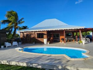 - une piscine en face d'une maison dans l'établissement Villa TYNO, à Le Moule