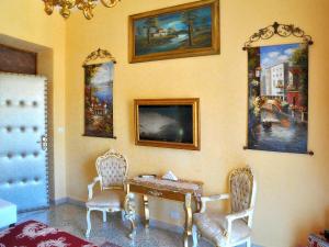 a room with a table and chairs and paintings on the wall at La Dolce Vita - Luxury House in Agrigento