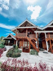 a log cabin with a deck and a blue sky at Tetebatu Flush Harmony in Tetebatu