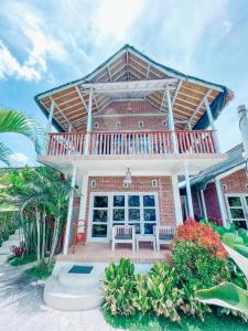 a brick house with a porch and a bench on a patio at Tetebatu Flush Harmony in Tetebatu