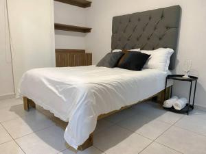 a bedroom with a large bed with a gray headboard at Modern gated townhouse 5 min from Plaza Altozano in Morelia
