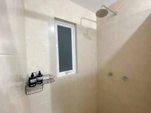 a white bathroom with a shower and a window at Modern gated townhouse 5 min from Plaza Altozano in Morelia