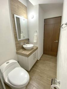 a bathroom with a white toilet and a sink at Modern gated townhouse 5 min from Plaza Altozano in Morelia