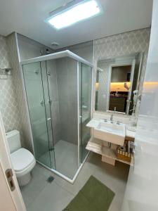 a bathroom with a shower and a toilet and a sink at Studio Patteo Bosque Maia in Guarulhos