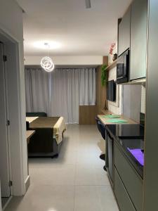a hotel room with a kitchen and a bedroom at Studio Patteo Bosque Maia in Guarulhos
