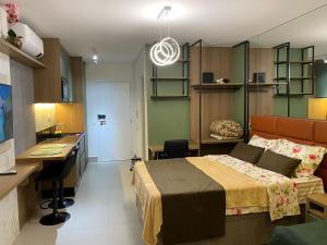 a bedroom with a bed and a desk and a sink at Studio Patteo Bosque Maia in Guarulhos