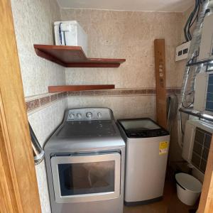 a small kitchen with a stove and a refrigerator at Apartamento familiar. in Cartagena de Indias