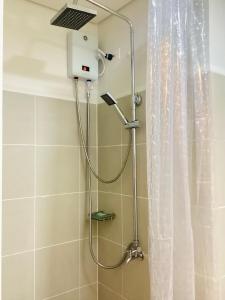 a shower with a shower head in a bathroom at Coast Residence Pasay in Manila