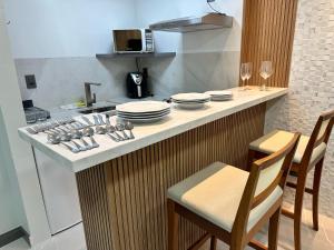 a kitchen with a counter with plates and dishes on it at Aconchegante FLAT 807 in Vila Velha