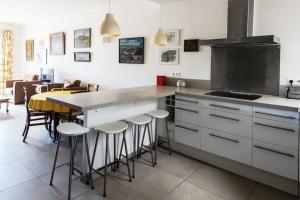 une cuisine avec un comptoir et une table avec des tabourets dans l'établissement Fleurs de Nice furnished flat, à Nice