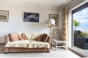 salon z kanapą i oknem w obiekcie Fleurs de Nice furnished flat w Nicei