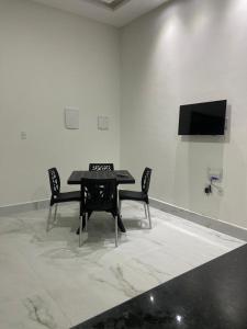 una mesa negra y 2 sillas en una habitación blanca en Carapibus casa de praia 02 en Conde