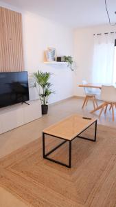 a living room with a coffee table and a tv at Peniche Supertubos Terrace in Peniche