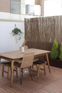une table et des chaises en bois sur une terrasse en bois dans l'établissement Peniche Supertubos Terrace, à Peniche