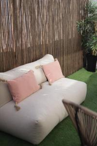 a white couch with two pink pillows on it at Peniche Supertubos Terrace in Peniche