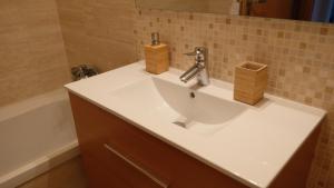 a bathroom with a white sink and a bath tub at Peniche Supertubos Terrace in Peniche +33 photos