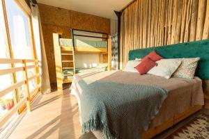 een slaapkamer met een bed met een groen hoofdeinde bij El Santuario in Paracas