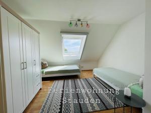 um quarto com uma cama e uma janela em Sonnige Ferienwohnung im Unterallgäu em Ettringen