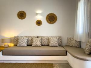 um sofá numa sala de estar com dois espelhos na parede em Aegean Balcony Studio em Áno Meriá