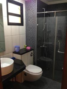 a bathroom with a shower and a toilet and a sink at Pool and Garden Facing Apartment in Riviera Foothills Near Baga, Arpora in Arpora