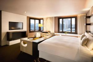 um quarto de hotel com uma cama grande e uma televisão de ecrã plano em THE PLAZA Seoul, Autograph Collection em Seul