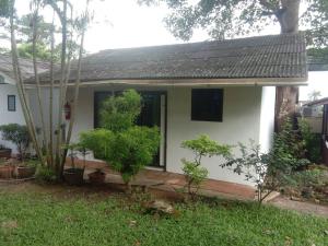 a small white house with trees in the yard at Faye Orchid Garden Resort in Ko Chang