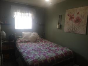 um quarto com uma cama com um edredão e uma janela em Paradise Inn em North Bay