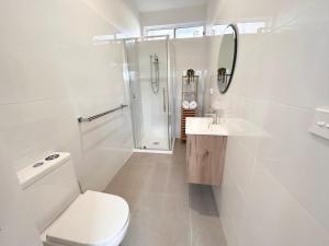 a white bathroom with a toilet and a shower at Sandford Views - Deluxe Studio in Sandford