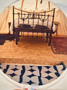 a bedroom with a bed in a tent at Infinite Skies Tipi's in Heydon