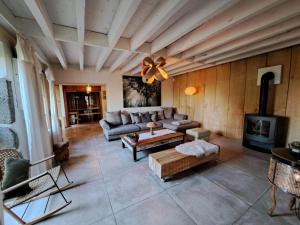 ein Wohnzimmer mit einem Sofa und einem Kamin in der Unterkunft Gîte Saint-Germain-Lespinasse, 7 pièces, 14 personnes - FR-1-496-6 in Saint-Germain-Lespinasse