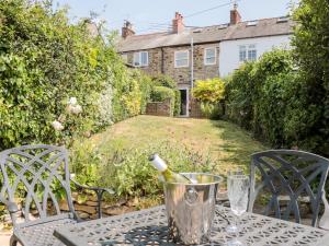 a table with a bottle of wine on top of it at Lea Cottage in Bridport