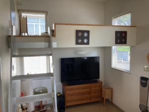 a living room with a bunk bed and a television at art.paradigm in Kushiro