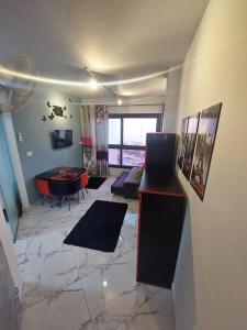 ein Wohnzimmer mit einem Tisch und einem Schreibtisch in der Unterkunft بورتو سعيد - Porto Said in `Ezbet Shalabi el-Rûdi