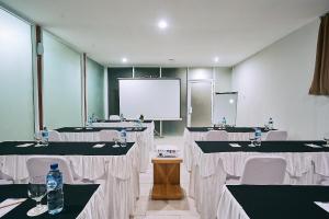 a conference room with tables and chairs and a screen at Horison Kuta Bali in Kuta +26 photos