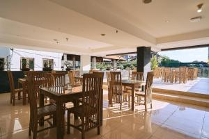 a restaurant with wooden tables and chairs and a patio at Horison Kuta Bali in Kuta