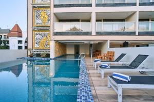 a house with a swimming pool in front of a building at Horison Kuta Bali in Kuta