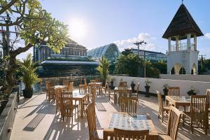 a patio with tables and chairs and a building at Horison Kuta Bali in Kuta