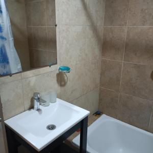 y baño con lavabo blanco y ducha. en Departamento Centrico San Martin en San Salvador de Jujuy