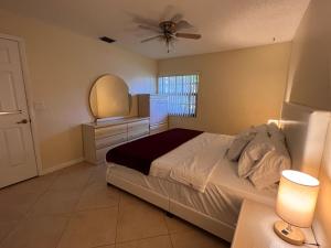 - une chambre avec un lit et un ventilateur de plafond dans l'établissement Entire Single Family home 3 bed 2 bath in water front big cozy back yard view, à Coconut Creek