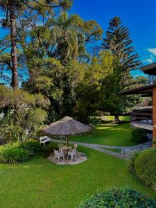 una mesa de picnic y una sombrilla en un patio en Natur Hotel, en Gramado