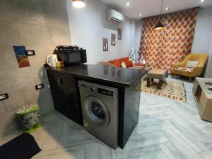 uma cozinha com uma máquina de lavar roupa na sala de estar em بورتو الجولف em El Alamein