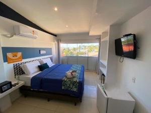 um quarto com uma cama e uma televisão em Costa Maris Beach Hotel Frente Mar no Guarujá