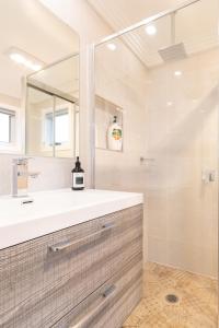 a bathroom with a sink and a mirror at Armidale Cottage - House 1 in Armidale