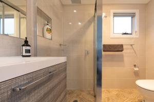 La salle de bains est pourvue d'une douche, d'un lavabo et de toilettes. dans l'établissement Armidale Cottage - House 1, à Armidale