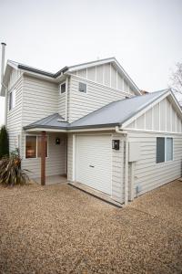 une maison blanche avec un garage dans l'établissement Armidale Cottage - House 1, à Armidale