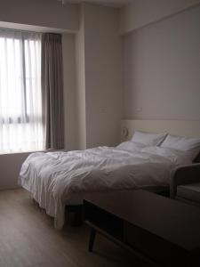 - une chambre avec un grand lit et une fenêtre dans l'établissement Yueshe House, à Jiaoxi