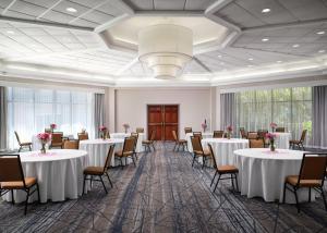 a banquet hall with tables and chairs and a chandelier at Holiday Inn Express and Suites New Orleans Airport, an IHG Hotel in Saint Rose