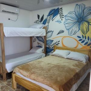 a bedroom with two bunk beds and a flowery wall at Ecohotel La Reserva in Piojó +30 photos