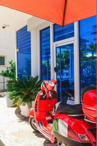 una moto roja estacionada frente a un edificio en Summer Dream Hotel, en Sarandë